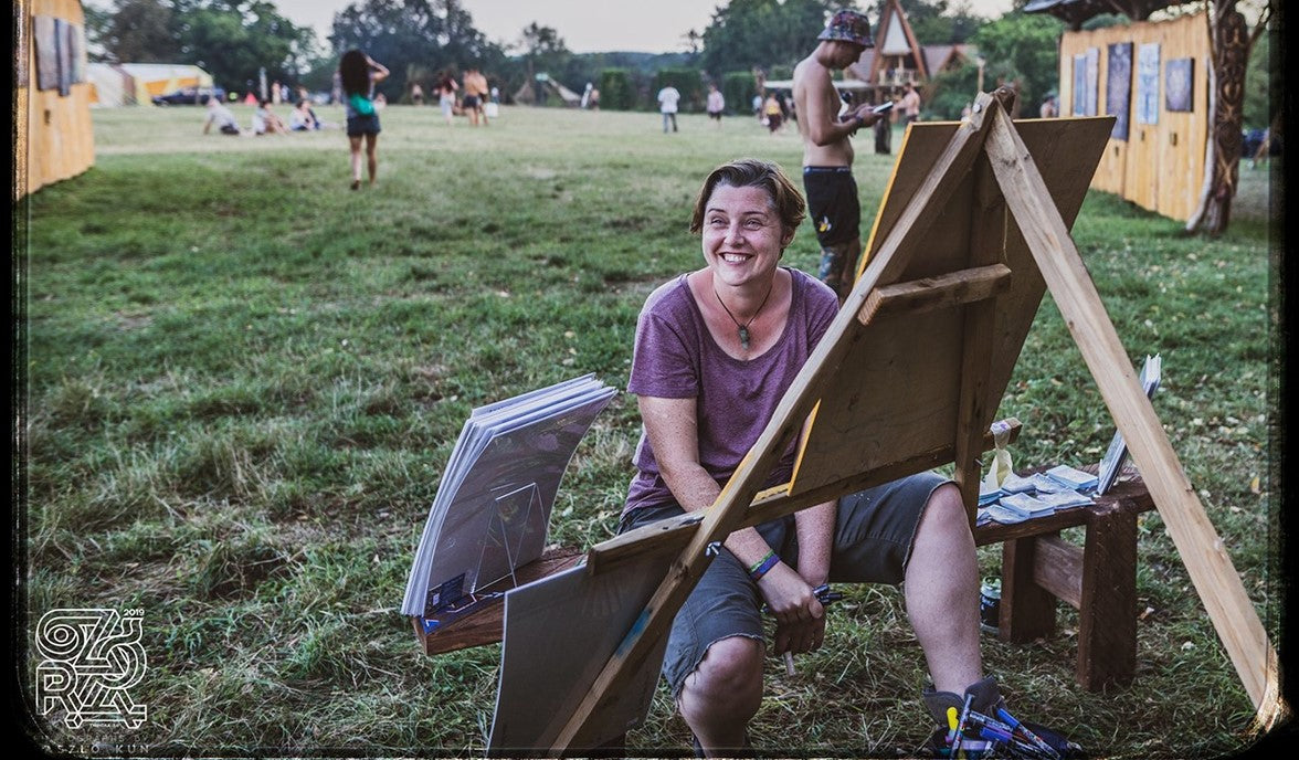 Kelly Boyle smiling whilst painting at Ozora festival